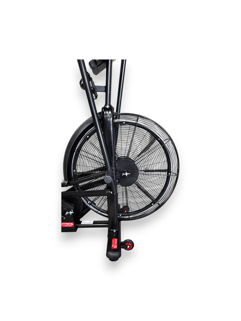 Close-up view of the Fitness Canada air bike large front steel fan wheel.
