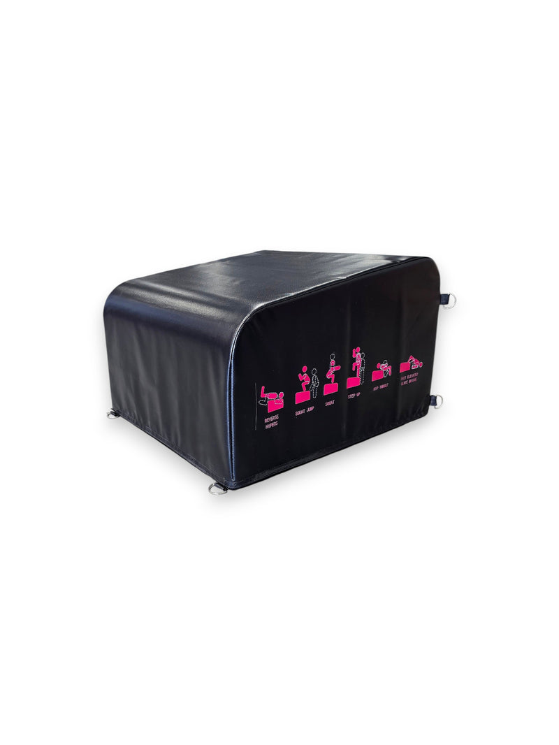 Angled view of the Fitness Canada black vinyl padded hip thrust and step up box on a gym floor, displaying pink instructional exercise icons on the side and heavy-duty steel D-ring resistance band anchors, as seen in image.